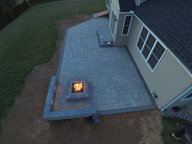 Aerial view of stone walkway with firepit lit
